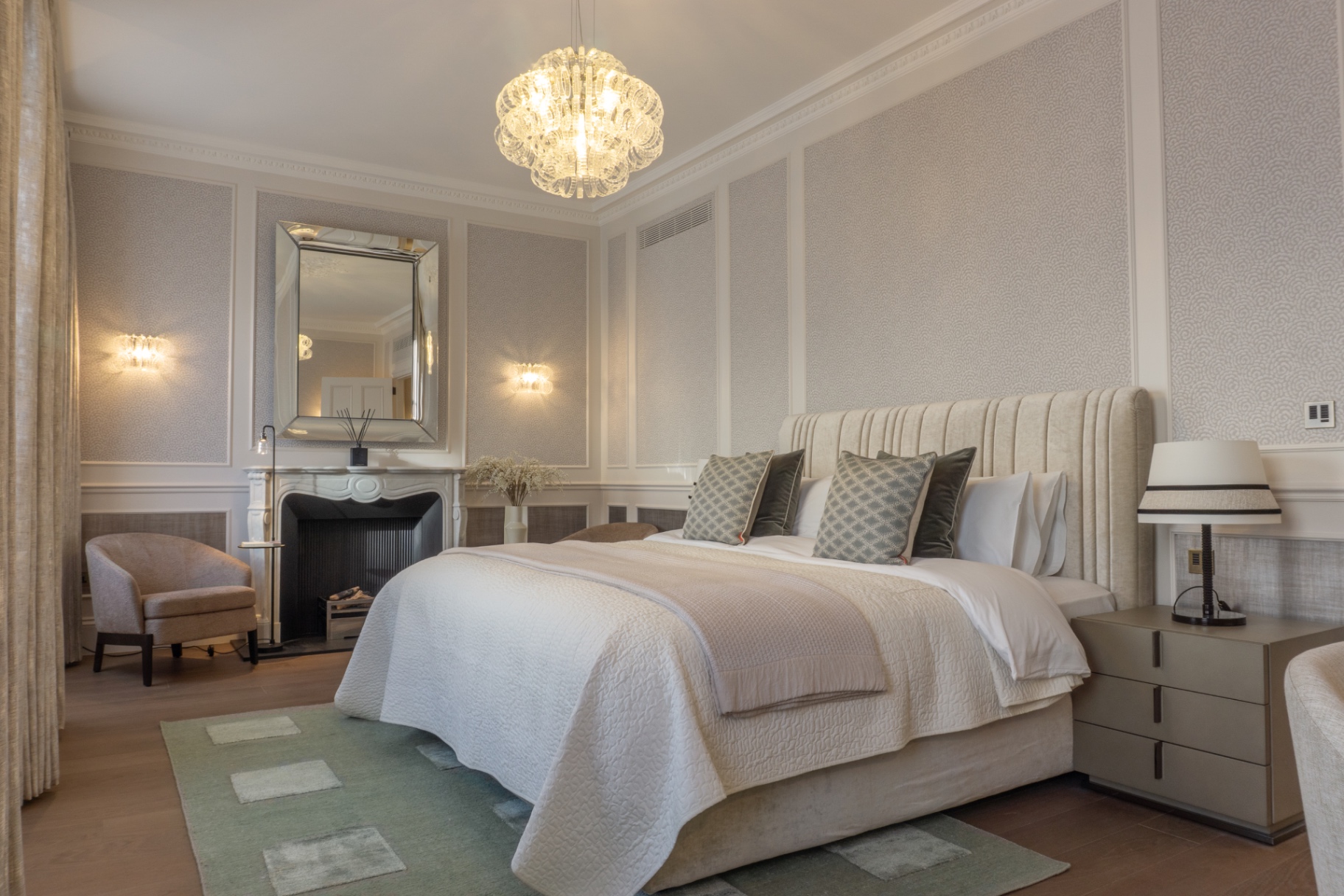 Principal bedroom with panelled walls and chandelier