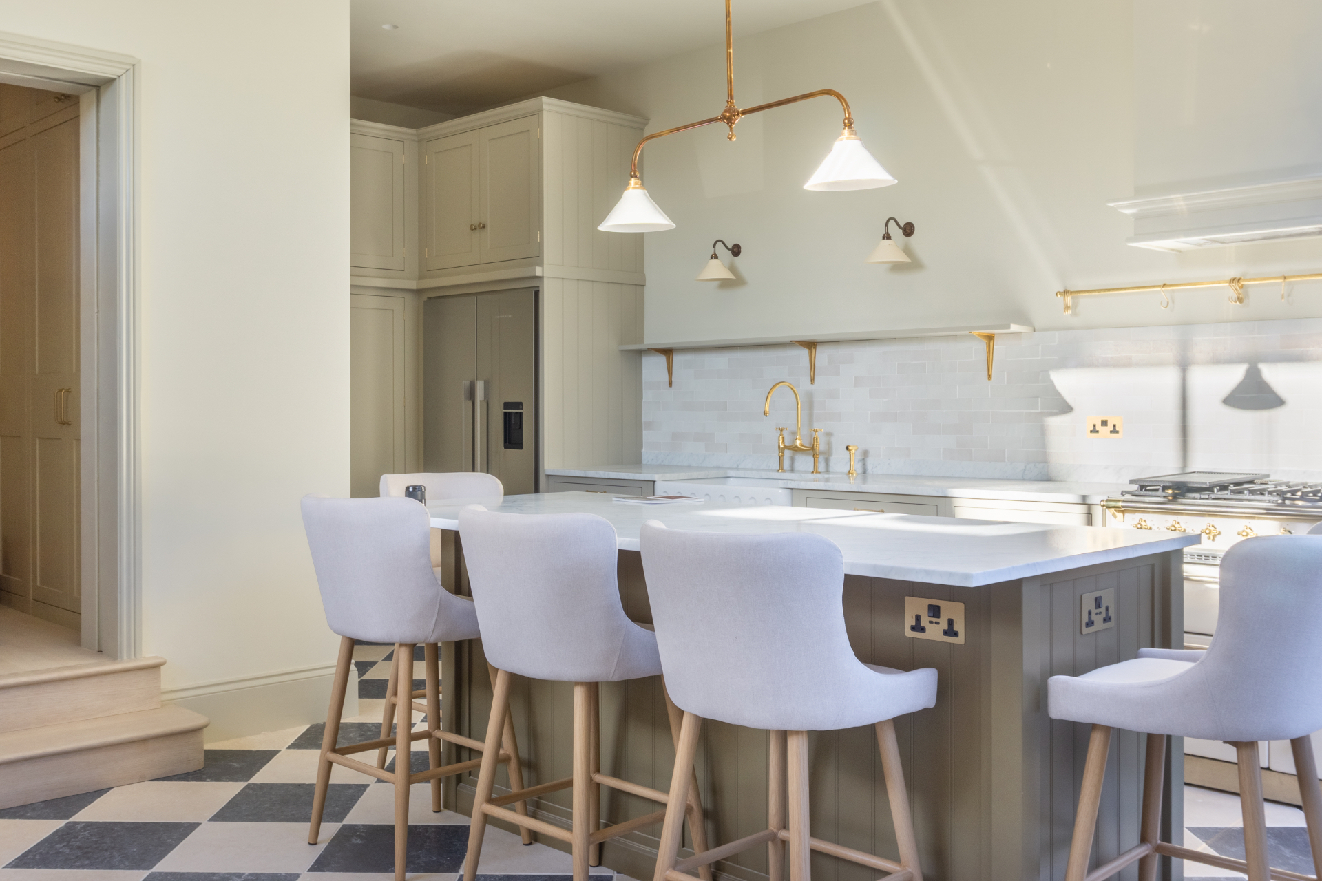 Kitchen island with marble worktop and upholstered bar stools