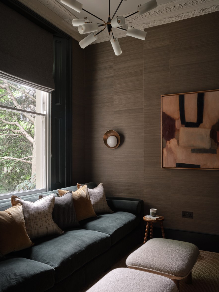 Sitting room with grasscloth feature walls, green velvet sofa and sash window